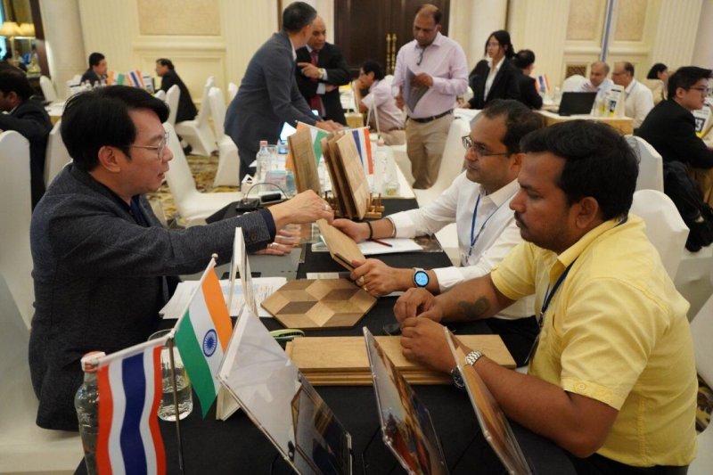 Business meeting with three colleagues sitting around a wooden table.